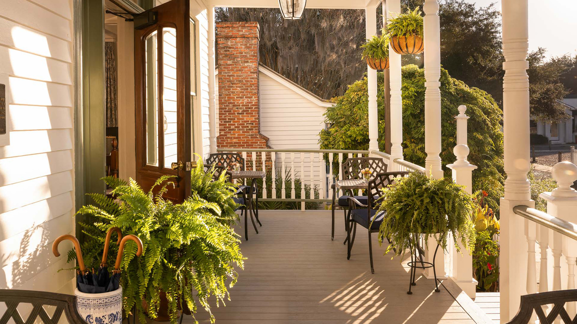 a porch with chairs and plants