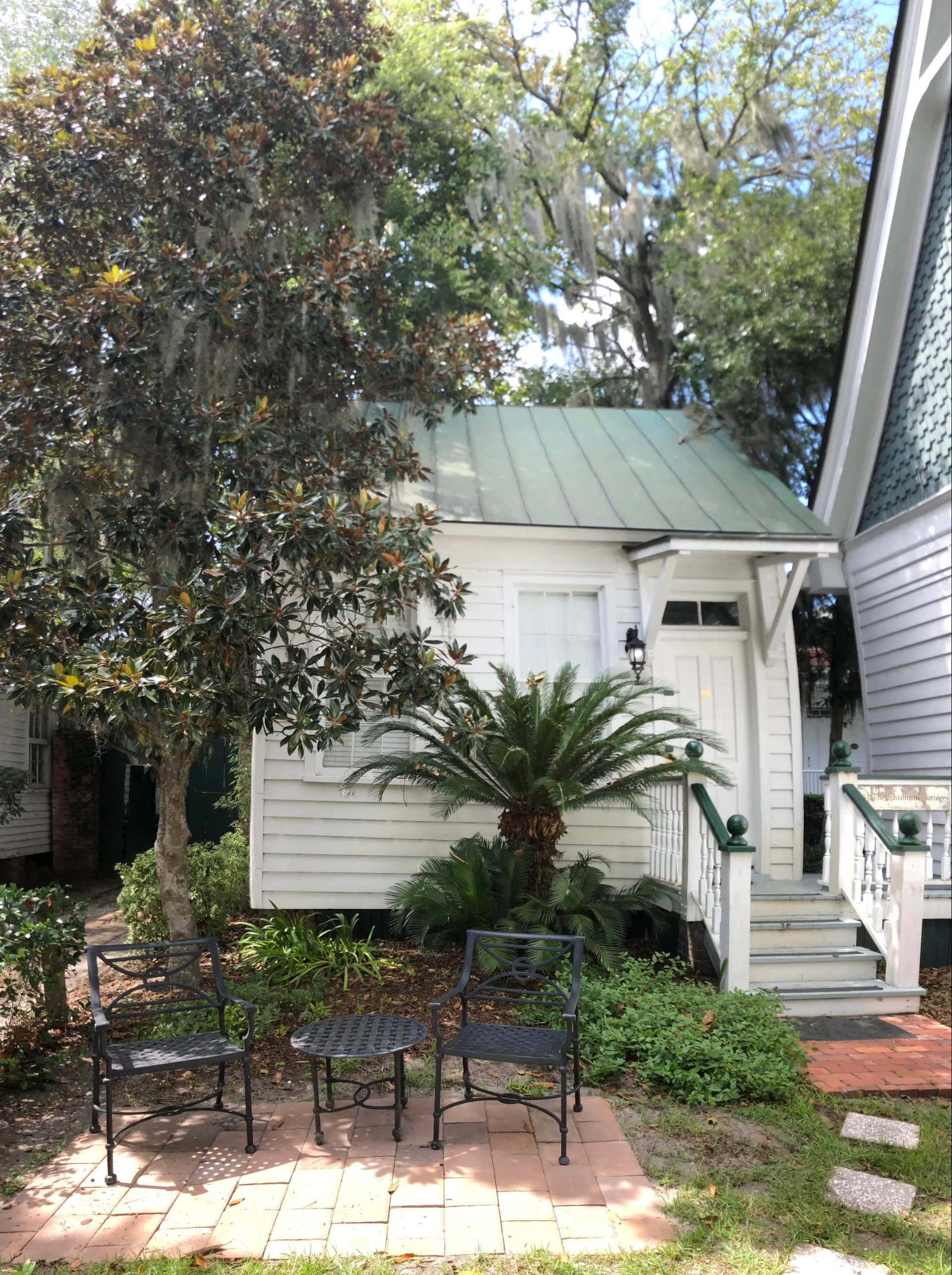 a white house with a green roof and a green roof