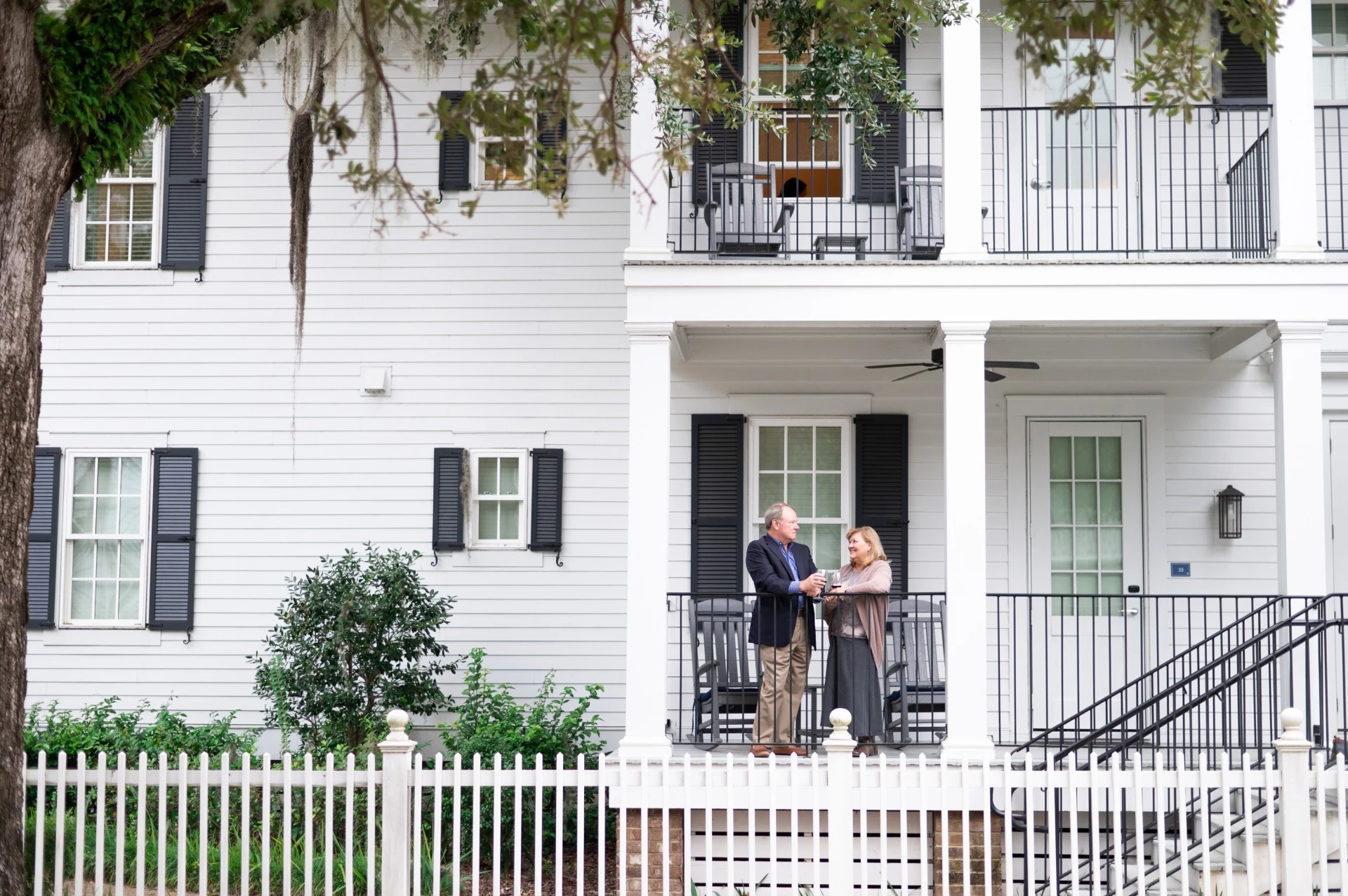 a man and woman standing on a porch of a house