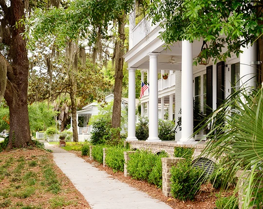a white house with columns and a walkway