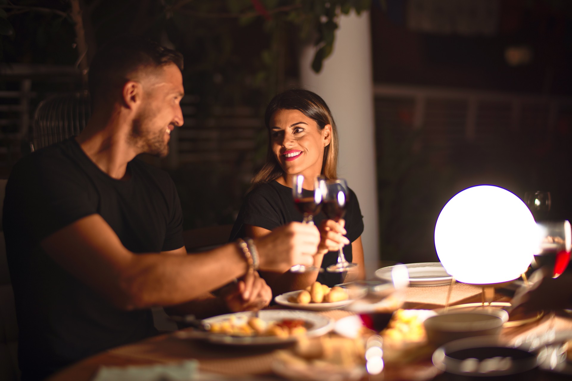 a man and woman drinking wine at a table