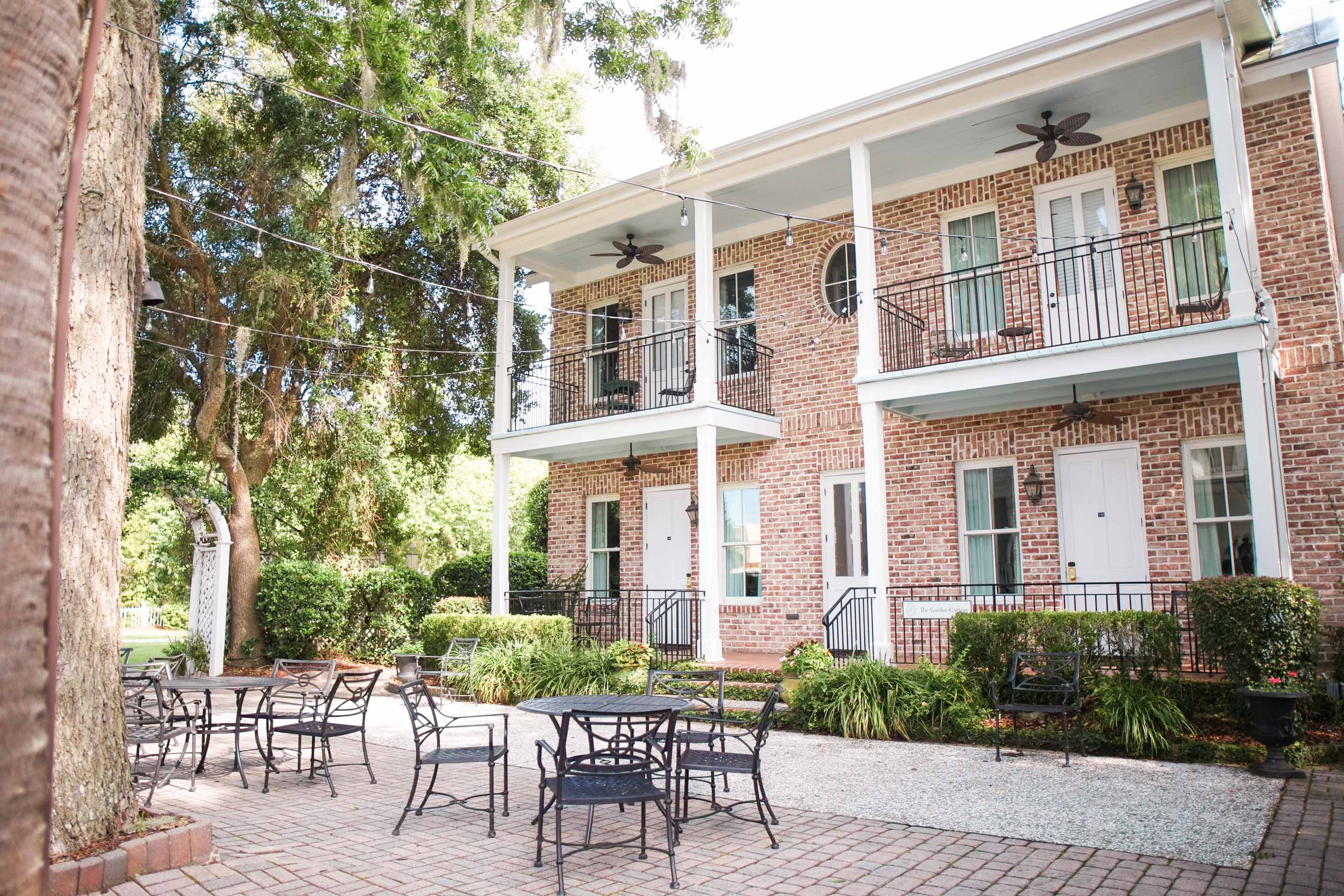 a brick building with a patio and chairs