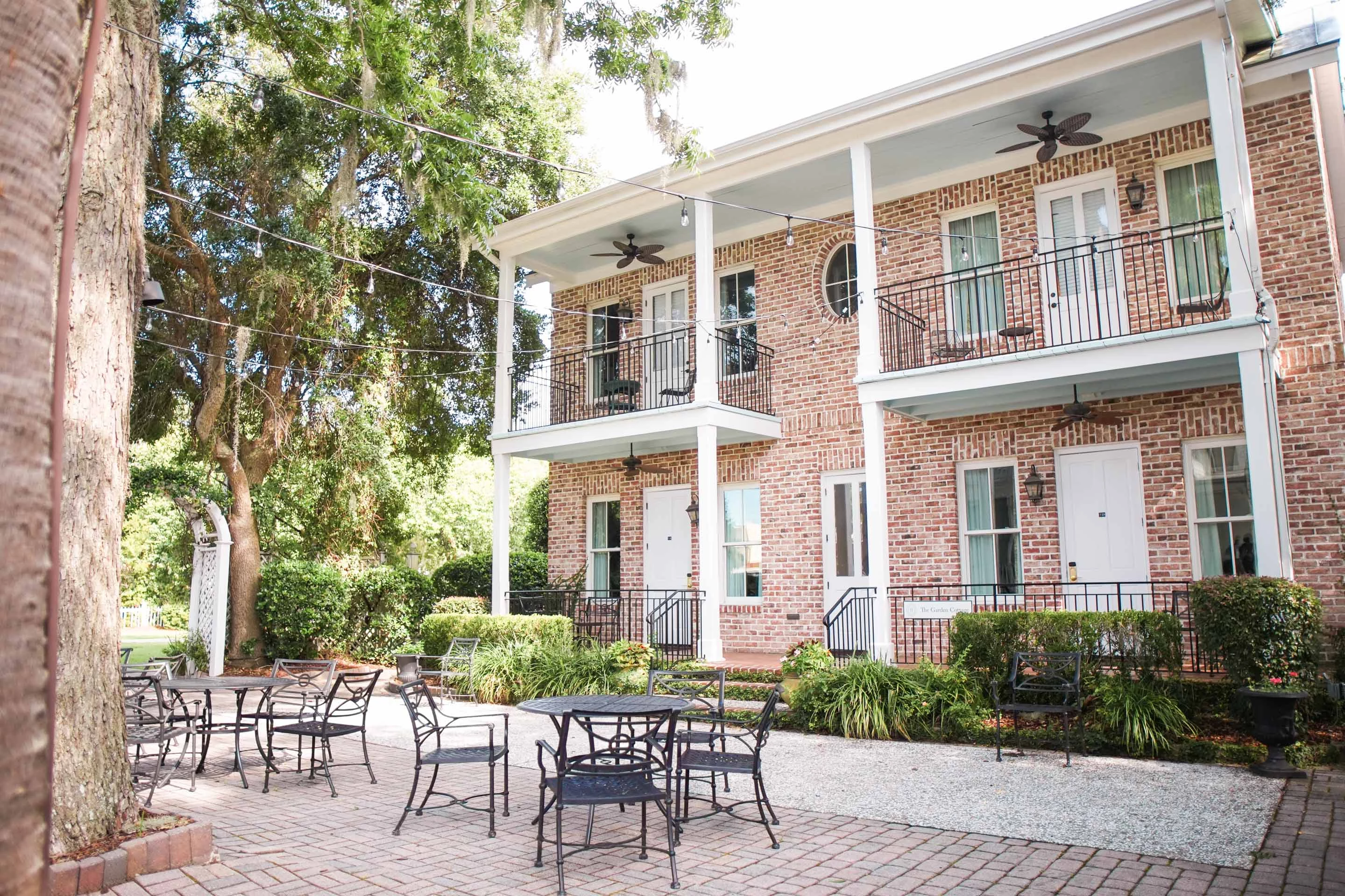 a brick building with a patio and chairs