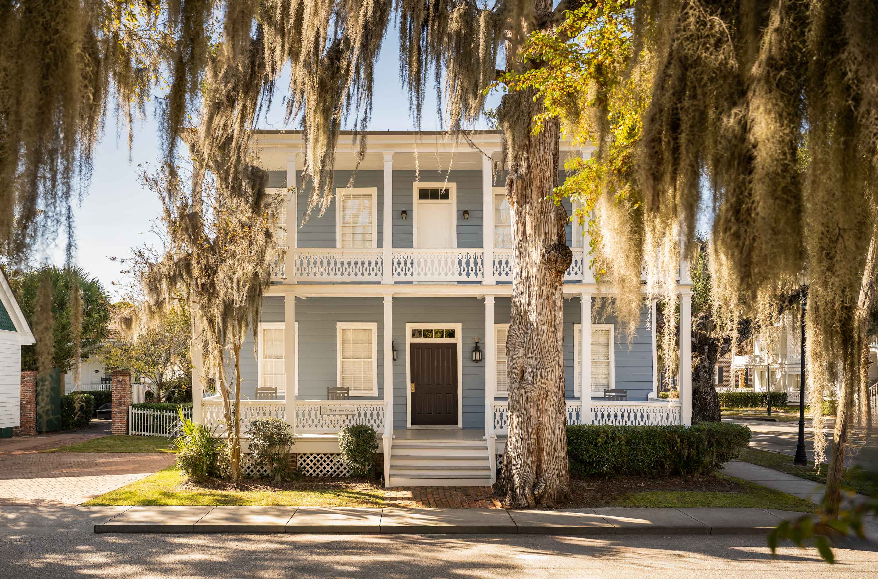 a house with trees and a sidewalk