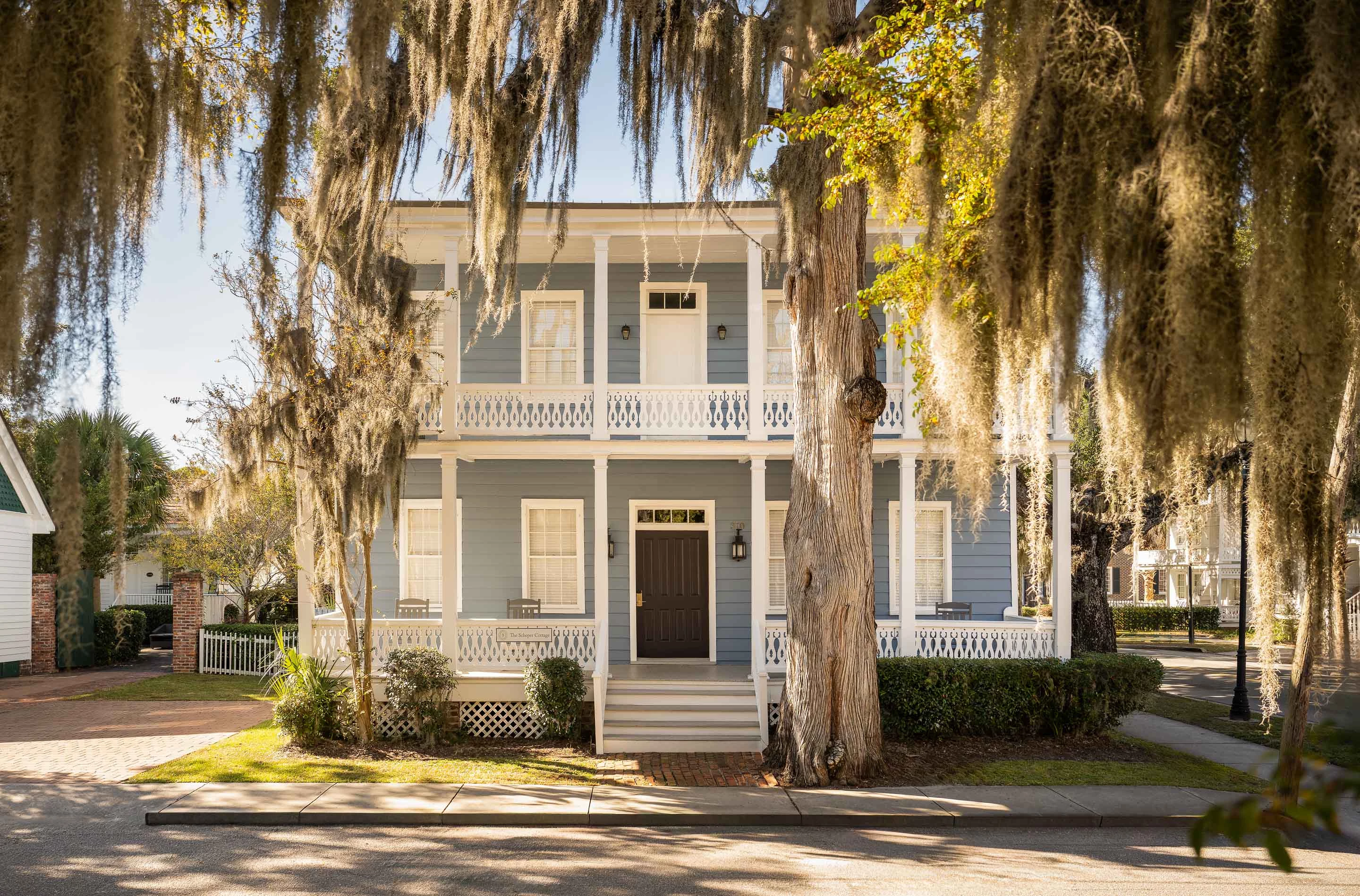 a house with trees and a sidewalk