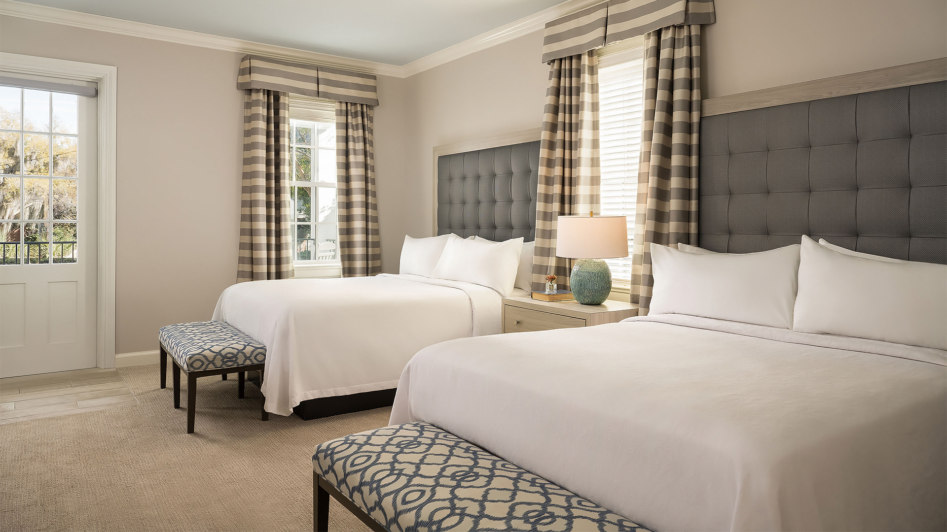 a room with two beds and a lamp