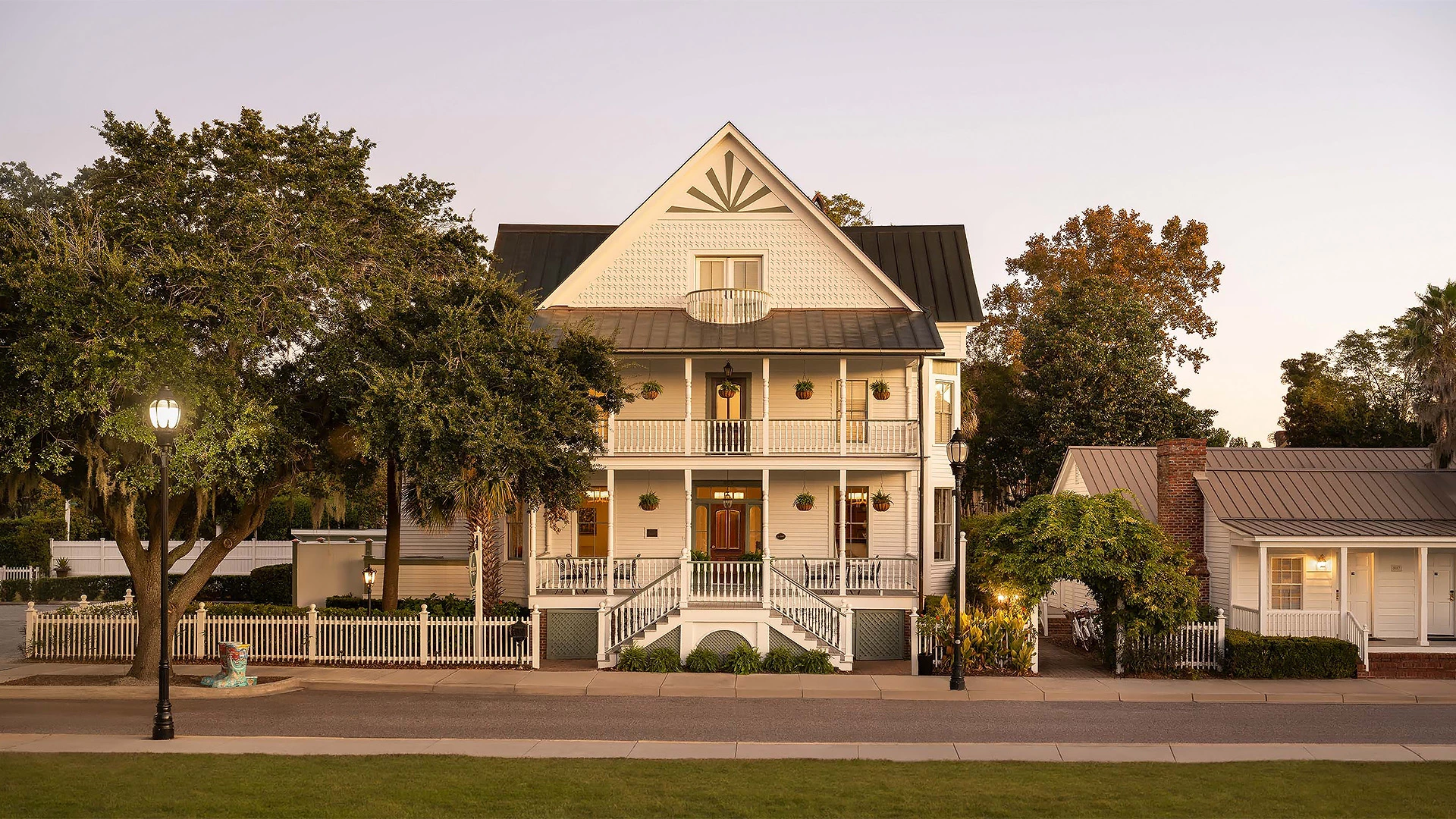 a house with a white picket fence and trees