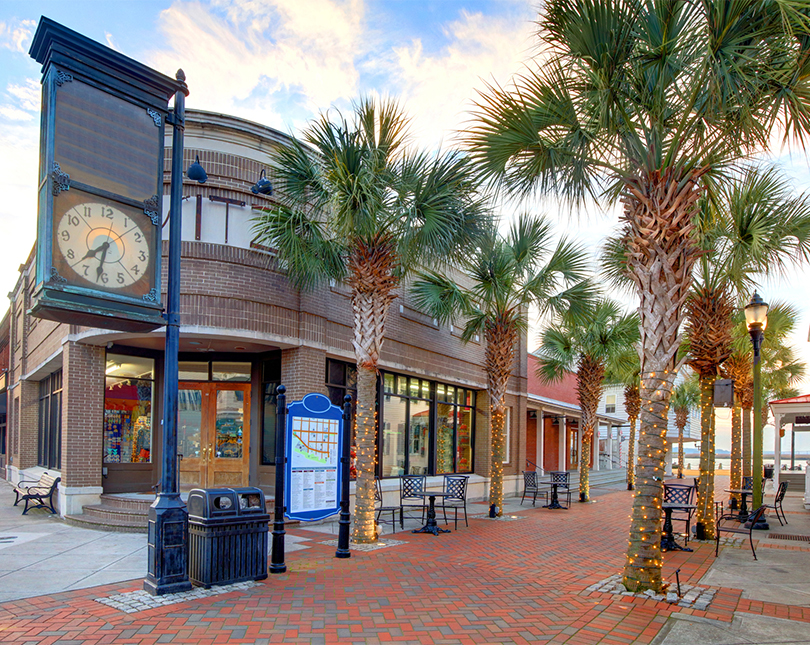 a building with palm trees and a clock