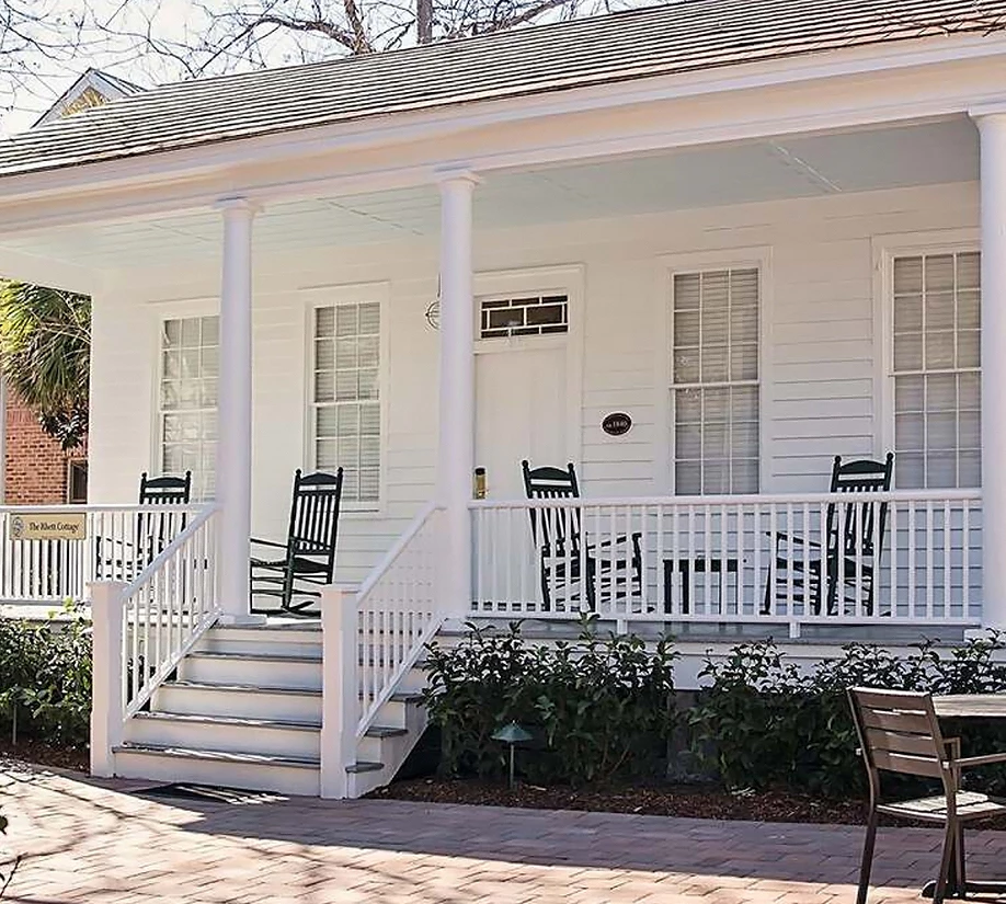 a white house with chairs on the porch