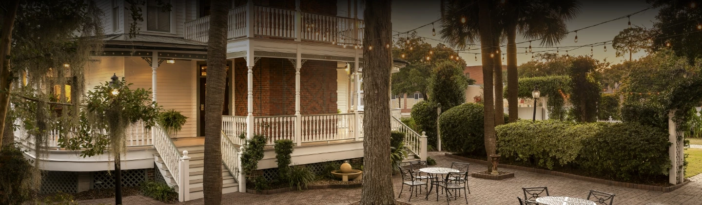 a patio area with a tree and chairs