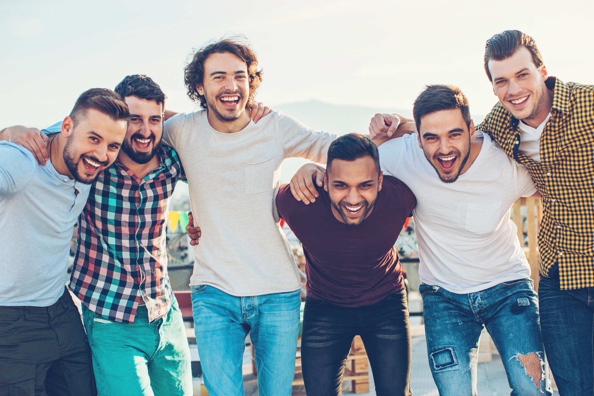 a group of men smiling and hugging