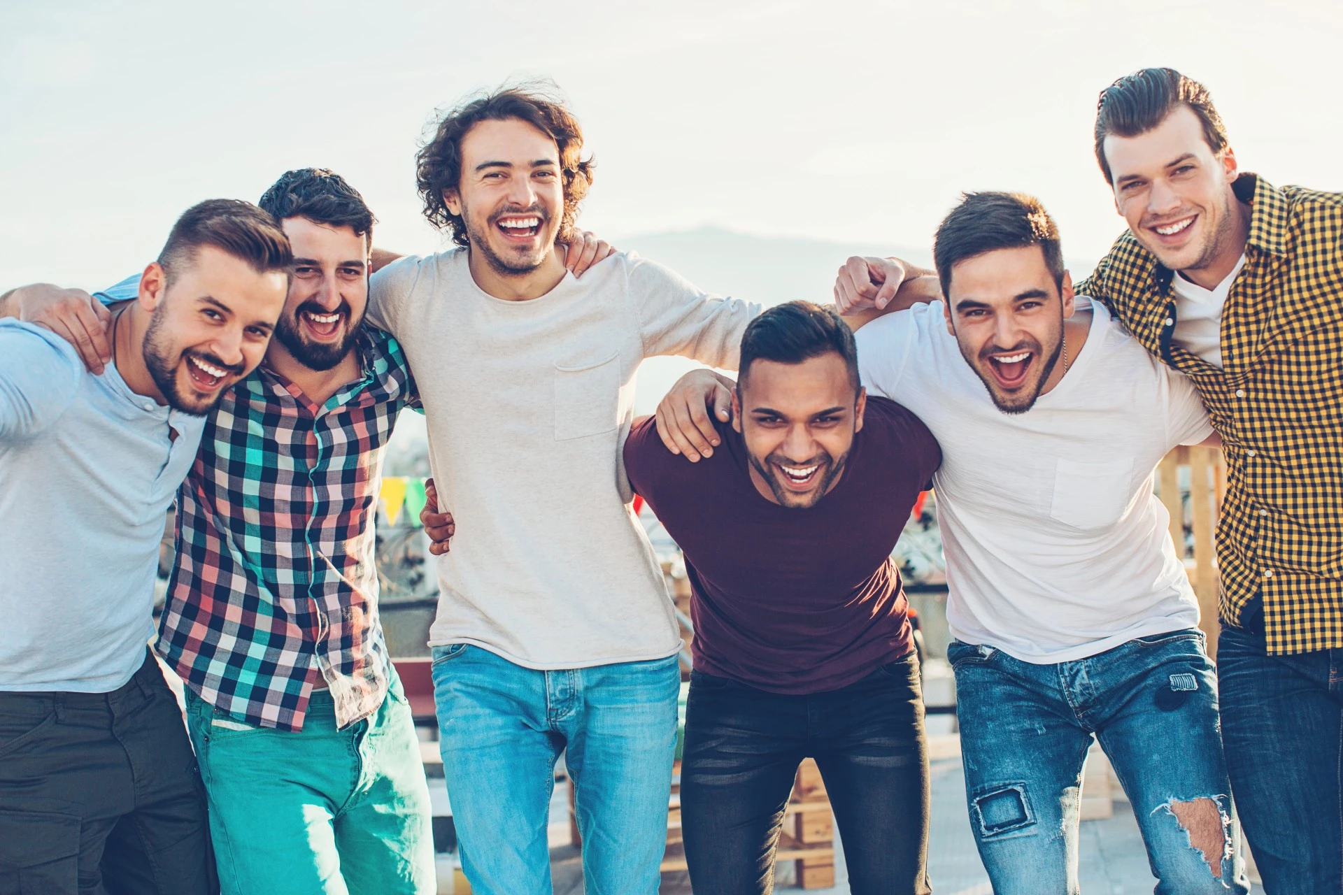 a group of men smiling and hugging