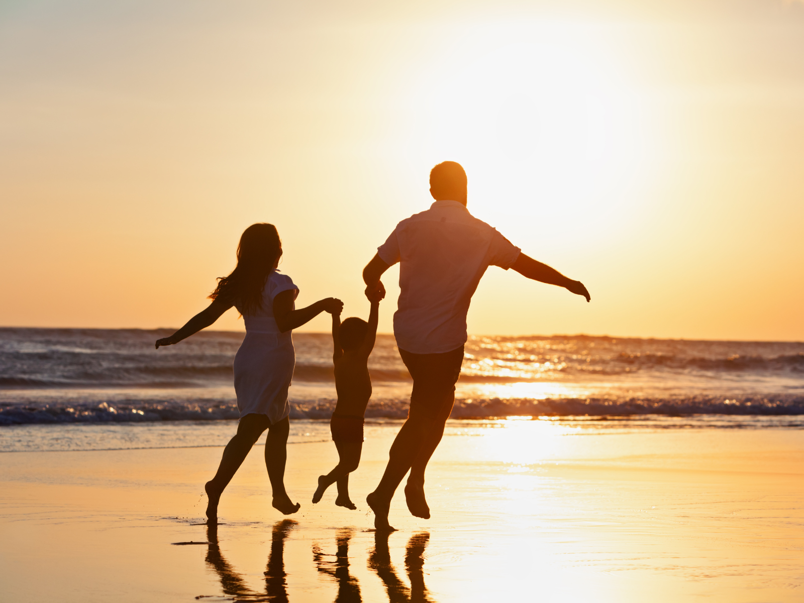 a man and woman running on a beach