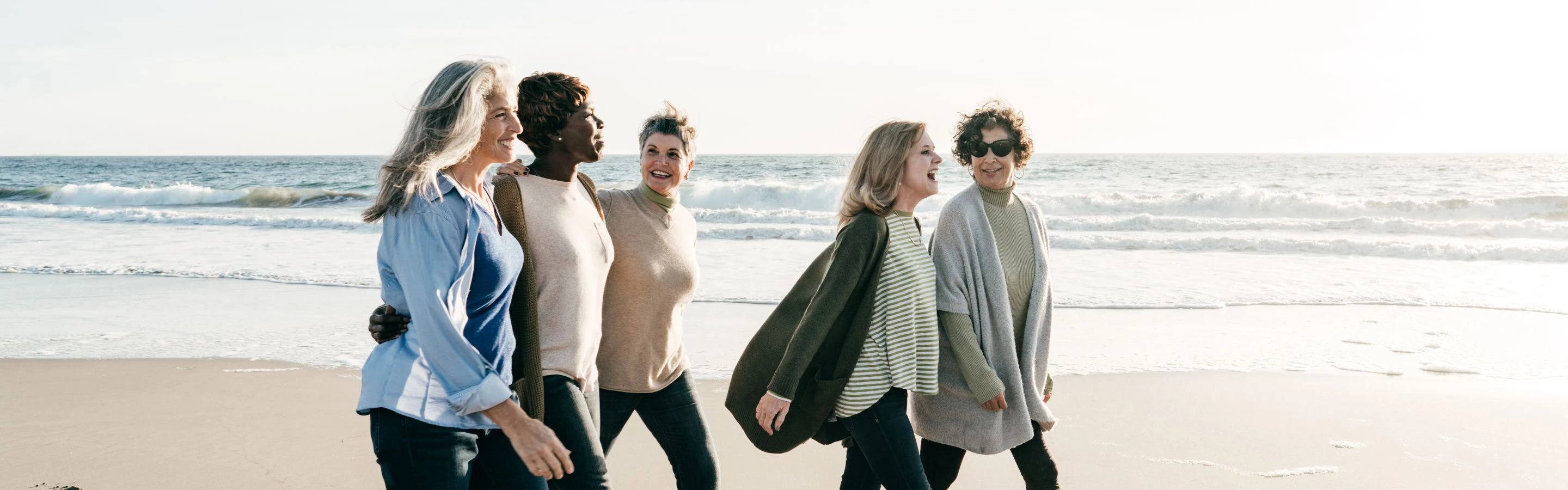 a group of women walking on a beach