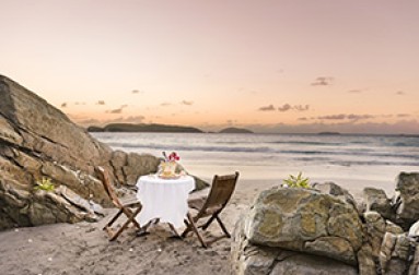 a table and chairs on a beach