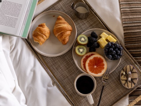 a tray of food on a bed