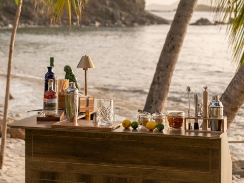 a bar with drinks and glasses on a beach