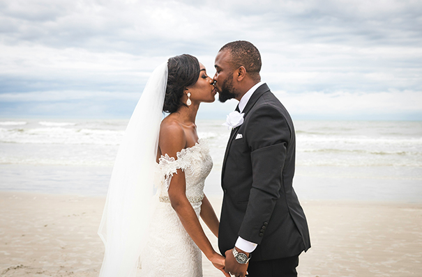 a man and woman kissing on a beach