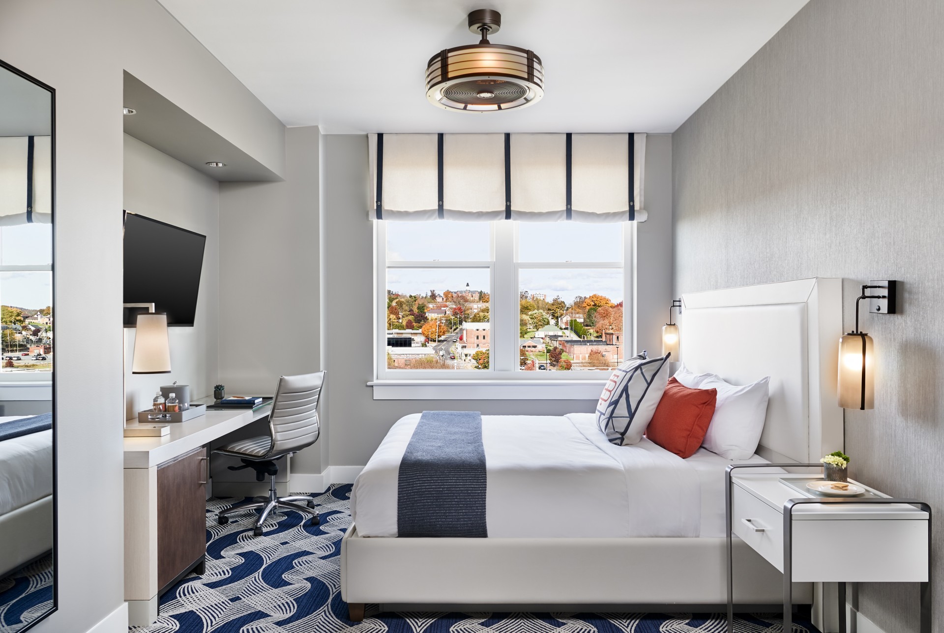 a room with a bed and desk and a window