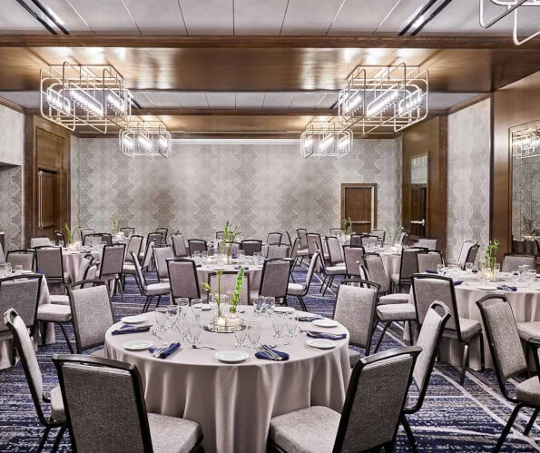 meeting space set up for an event with glassware and flowers on the table