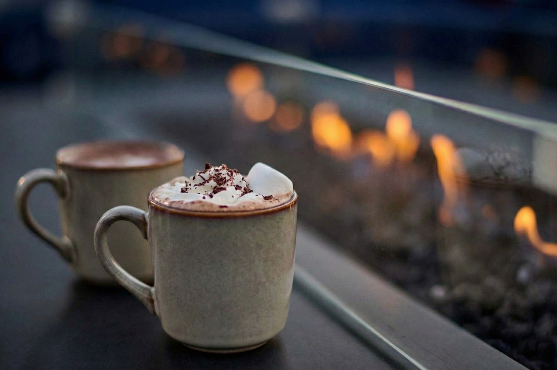 two cups of hot chocolate with whipped cream and marshmallows