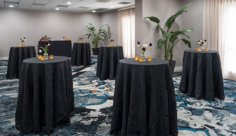 a group of tables with candles and flowers in a room