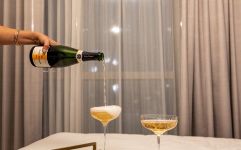 a person pouring champagne into a tray of food