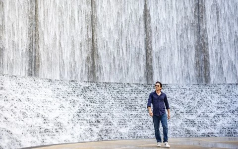 a man standing in front of a waterfall