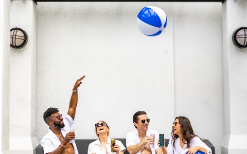 a group of people sitting on a couch with a beach ball