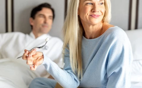 a woman holding a fork and a bowl of food