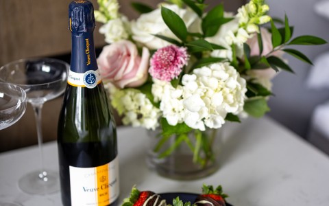 a bottle of champagne and strawberries on a table
