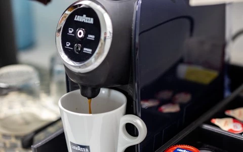 a person's hand on a coffee machine