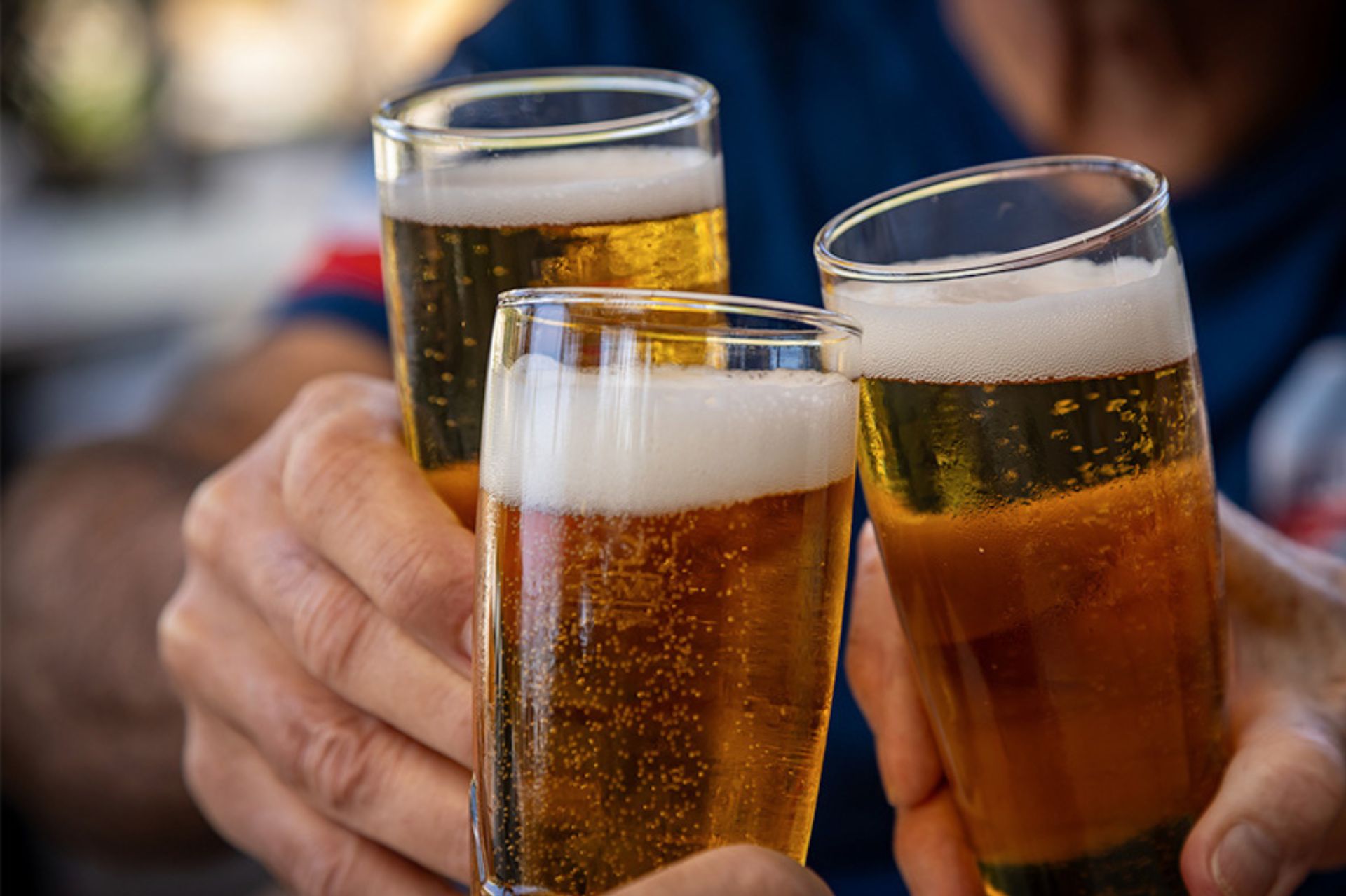 a group of people holding up glasses of beer