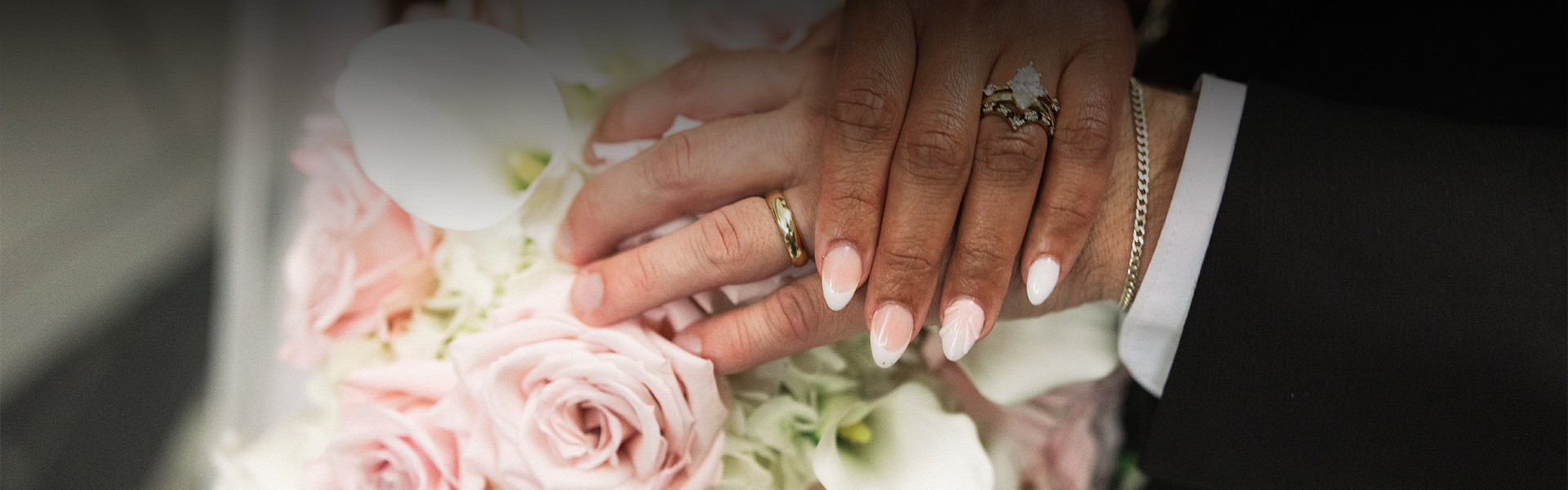 a close up of hands with wedding rings