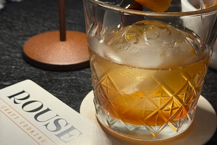 a glass with ice and a drink in it