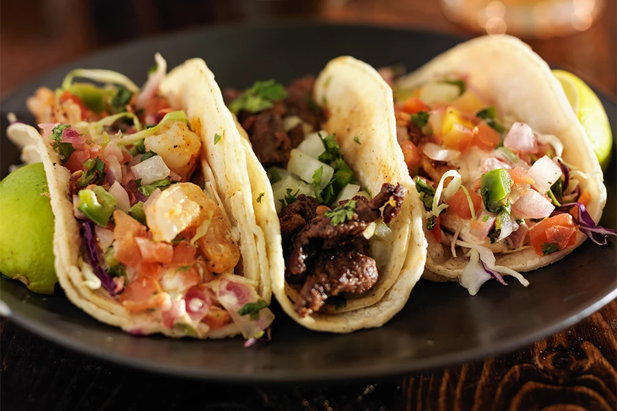 a plate of tacos on a wooden surface