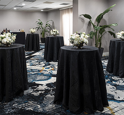 a group of tables with black cloths