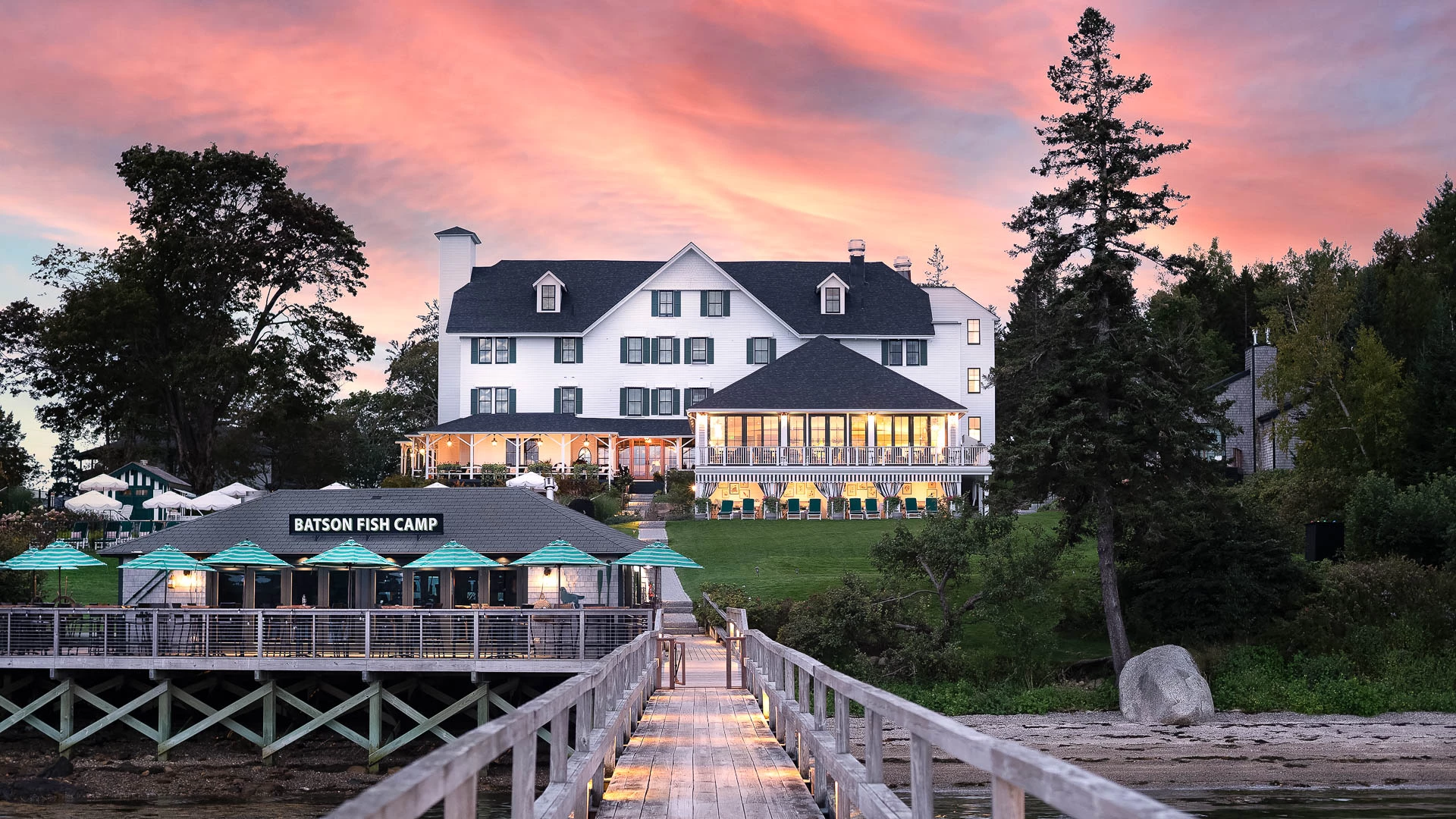 a dock leading to a large white house