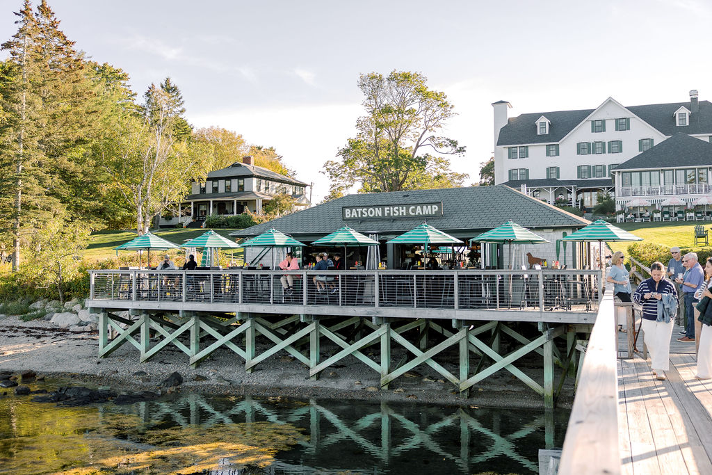 a bridge over water with a building and umbrellas