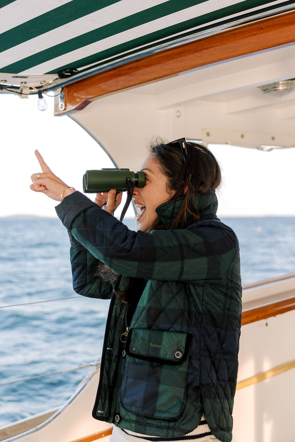 a woman looking through binoculars on a boat