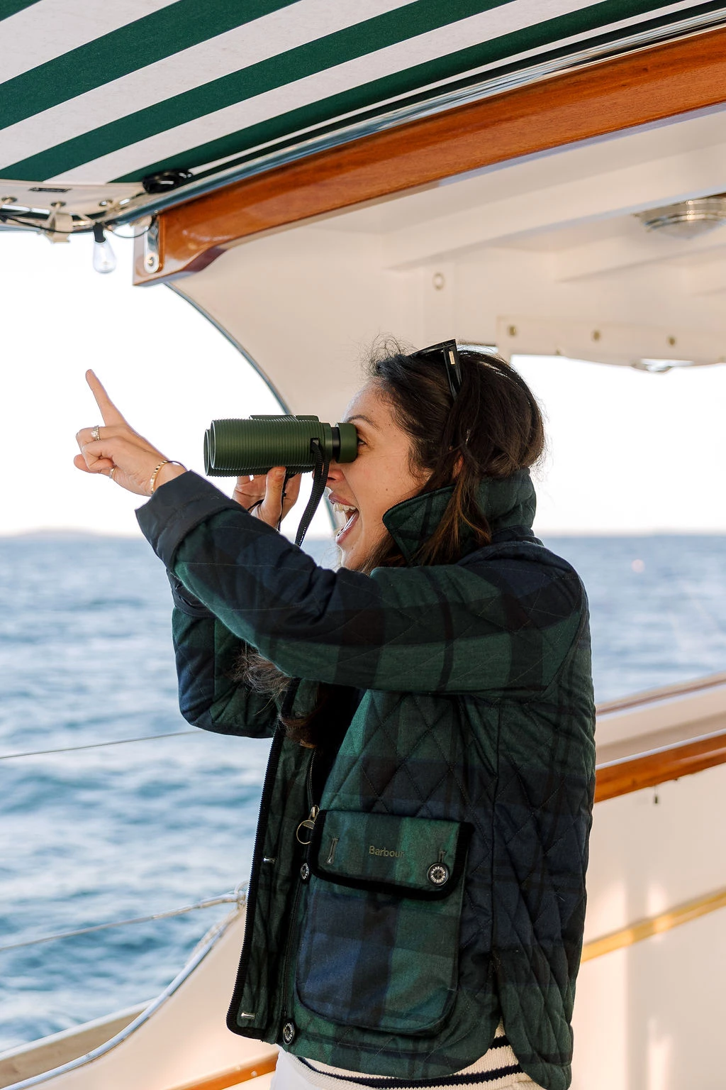 a woman looking through binoculars on a boat