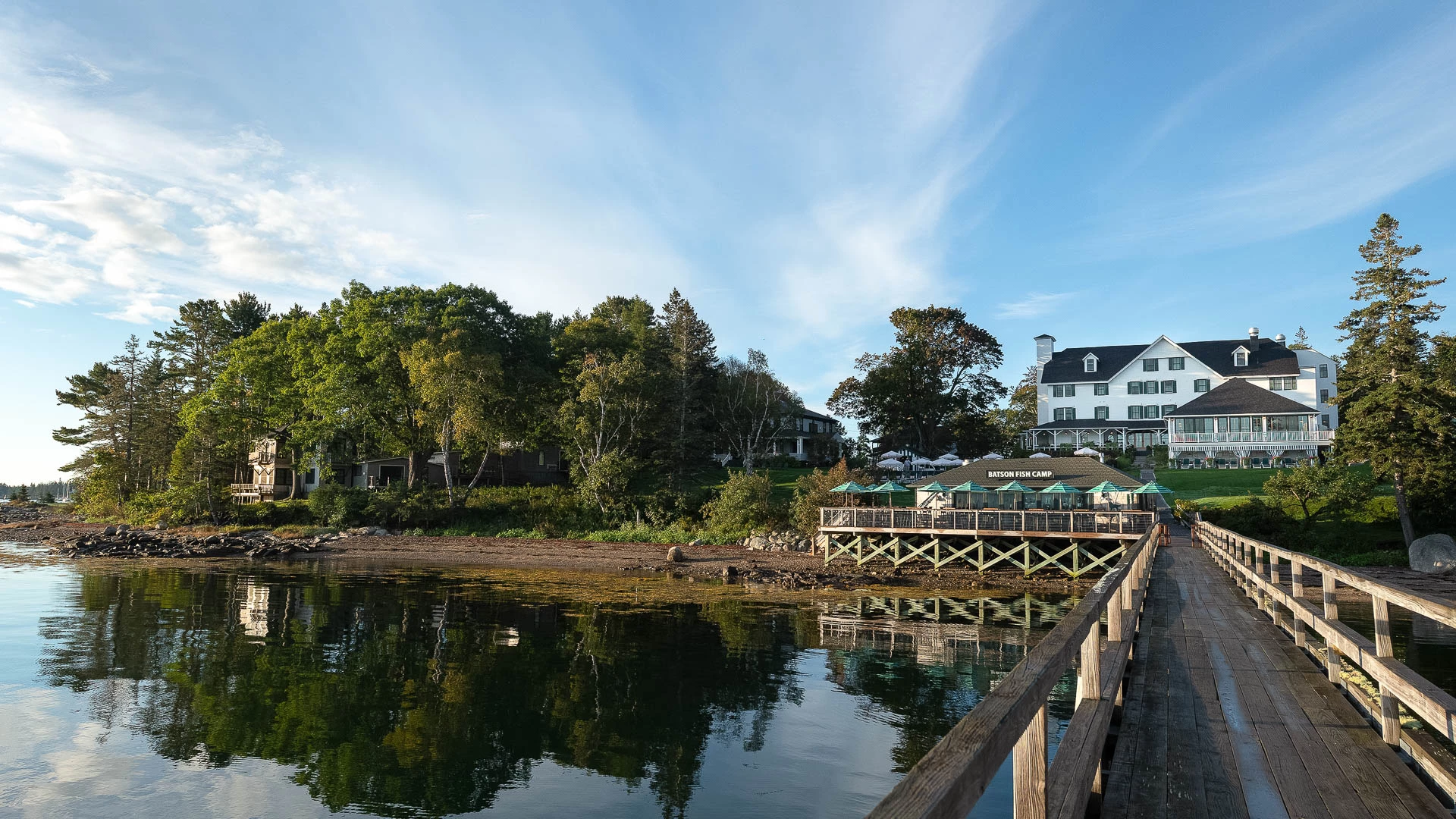 a dock with a building and trees in the background