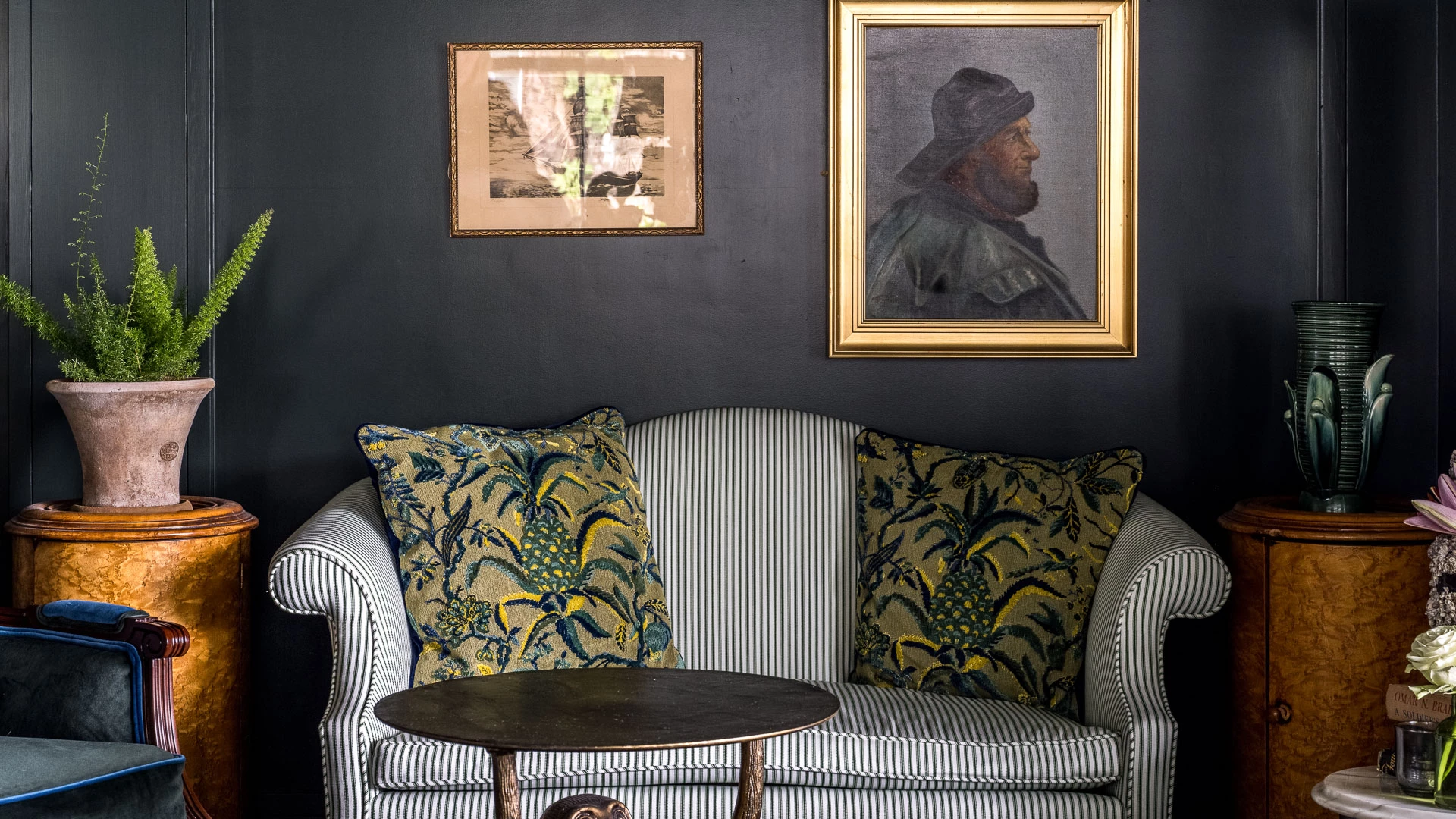 a couch with pillows and a table with a picture on the wall
