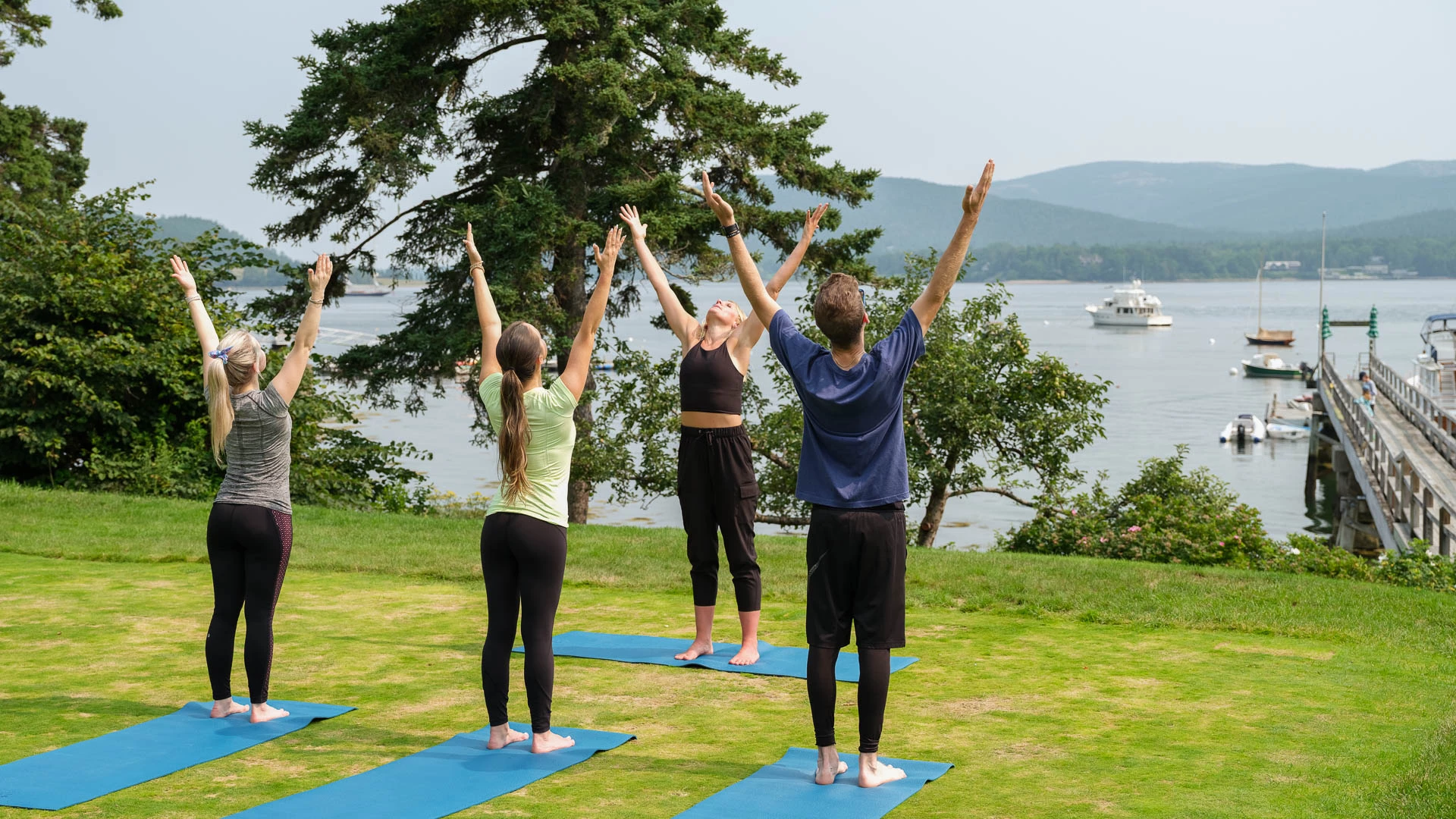 a group of people doing yoga on mats with their hands up