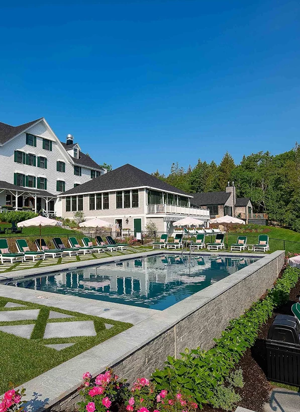 a pool with chairs and a building in the background