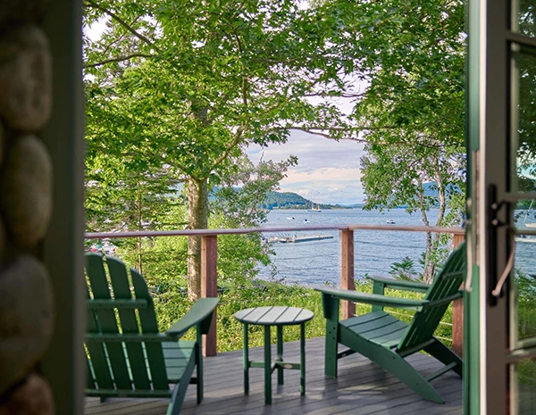 a deck with chairs and a table overlooking water