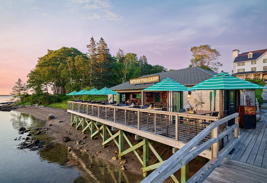 a building with a wooden deck and umbrellas on the side of the building