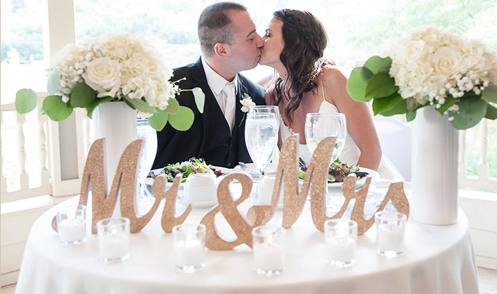 bride and groom kissing with flowers next to them