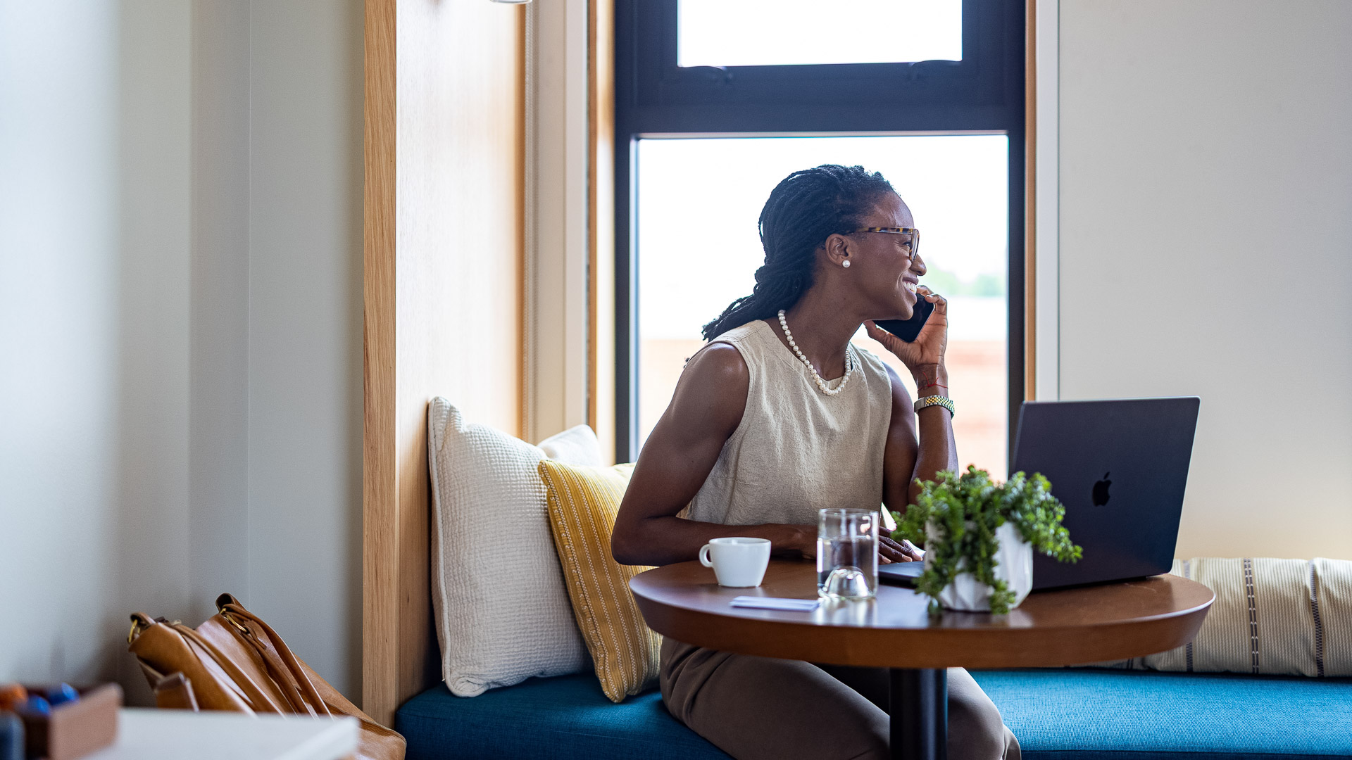 a woman sitting at a table talking on a cell phone