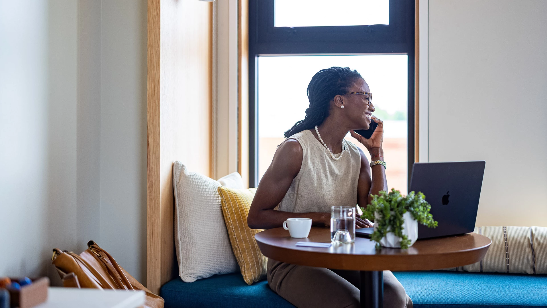 a woman sitting at a table talking on a cell phone